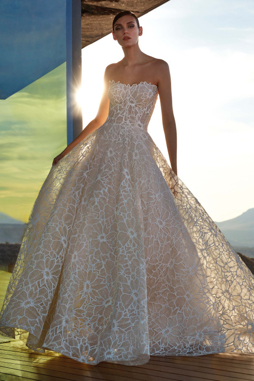 Strapless gown with bold floral lace overlay and full, flowing skirt that catches the light Strapless gown with bold floral lace overlay and full, flowing skirt that catches the light