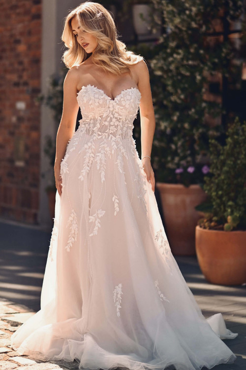 This strapless sweetheart gown enchants with 3D floral appliqués and a dreamy, flowing tulle skirt This strapless sweetheart gown enchants with 3D floral appliqués and a dreamy, flowing tulle skirt