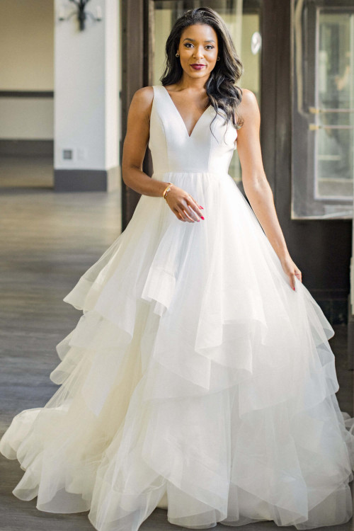 Modern minimalism meets fairytale flair in this tiered tulle ball gown with a sleek V-neckline Modern minimalism meets fairytale flair in this tiered tulle ball gown with a sleek V-neckline