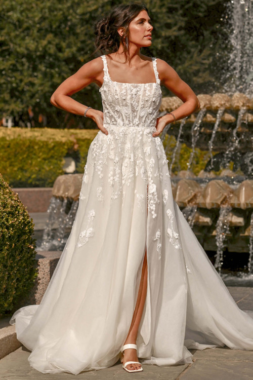 Romantic floral appliqués cascade down a soft A-line skirt with a modern slit Romantic floral appliqués cascade down a soft A-line skirt with a modern slit