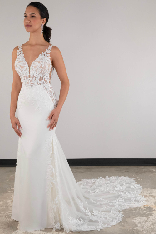 This gown stuns with leafy lace appliqués, sheer bodice detail, and a flowing chapel train This gown stuns with leafy lace appliqués, sheer bodice detail, and a flowing chapel train