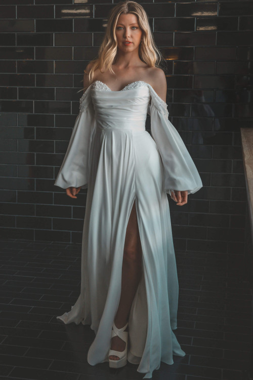 Romantic elegance shines in this pearl-trimmed gown with billowy sleeves and a daring slit Romantic elegance shines in this pearl-trimmed gown with billowy sleeves and a daring slit