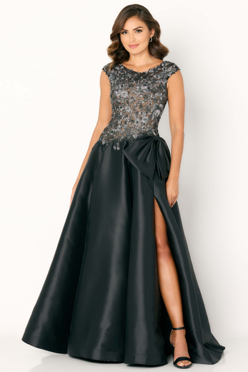 Black ball gown with illusion floral bodice, full satin skirt, and oversized bow Black ball gown with illusion floral bodice, full satin skirt, and oversized bow