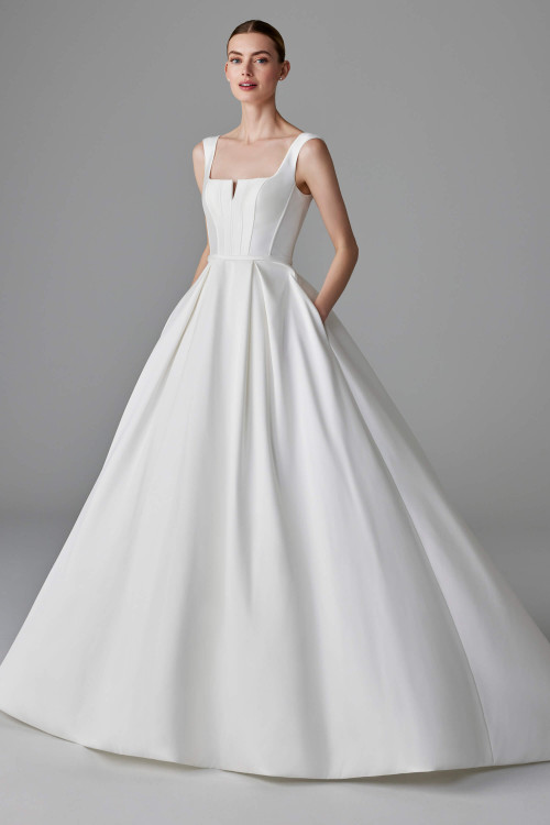 Sleek ball gown with square neckline, structured bodice, and box-pleated skirt with hidden pockets Sleek ball gown with square neckline, structured bodice, and box-pleated skirt with hidden pockets