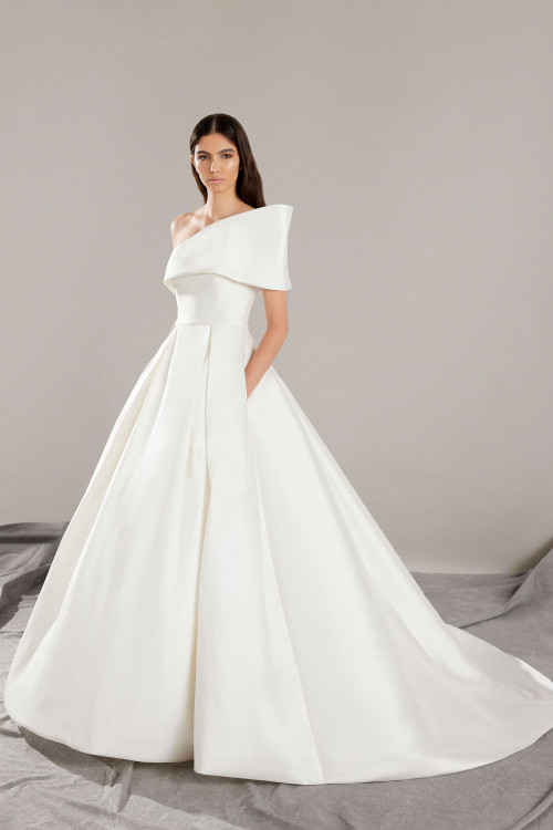 This one-shoulder ball gown stuns with sculpted folds and elegant box pleats This one-shoulder ball gown stuns with sculpted folds and elegant box pleats
