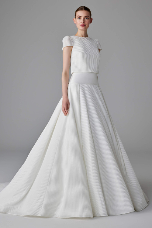 Modern pleated gown with detachable cap sleeved jacket and a structured dropped waistline Modern pleated gown with detachable cap sleeved jacket and a structured dropped waistline