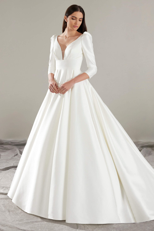 Minimalist magic meets timeless grace in this structured ballgown with a plunging neckline and sleeves Minimalist magic meets timeless grace in this structured ballgown with a plunging neckline and sleeves