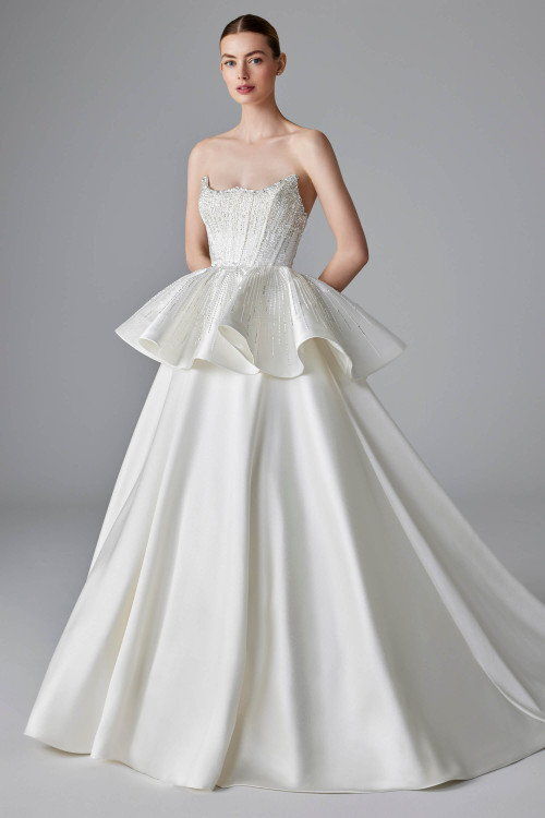 Ballgown with a sculpted strapless bodice adorned in pearl beading meets a dramatic peplum Ballgown with a sculpted strapless bodice adorned in pearl beading meets a dramatic peplum