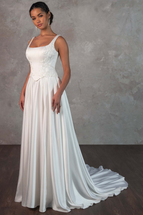 A regal square neckline meets a corset-inspired bodice with lace details, and flowing satin skirt in effortless elegance A regal square neckline meets a corset-inspired bodice with lace details, and flowing satin skirt in effortless elegance