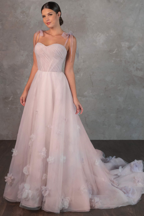 Whimsical tulle bows and scattered floral appliqués bring a fairytale touch to this dreamy blush gown