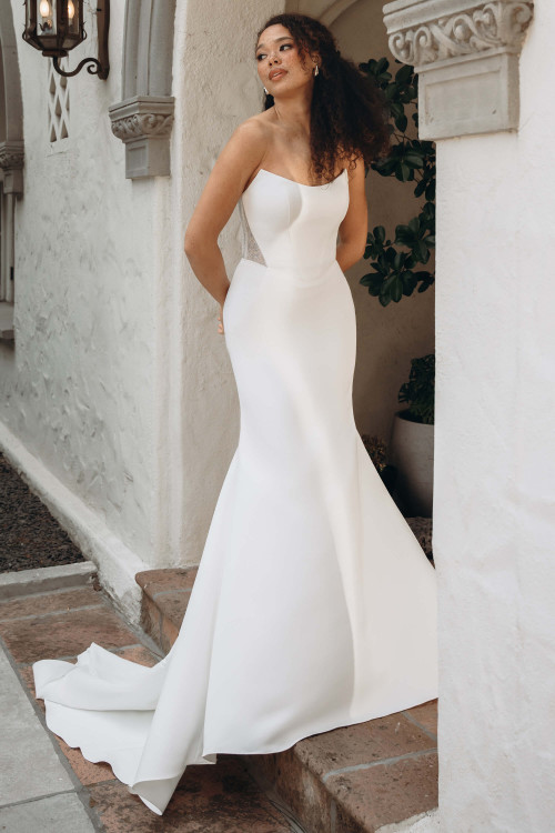 Fit-and-flare wedding dress with soft scoop neckline and lace side cutouts, front view. Fit-and-flare wedding dress with soft scoop neckline and lace side cutouts, front view.