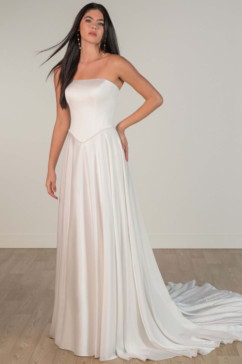 Front view of satin A-line wedding gown with straight neckline and delicate beaded trim. Front view of satin A-line wedding gown with straight neckline and delicate beaded trim.