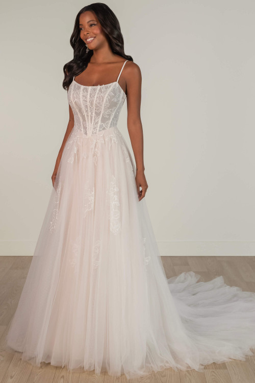 Romantic tulle wedding gown with floral embroidery and corset bodice featuring spaghetti straps. Romantic tulle wedding gown with floral embroidery and corset bodice featuring spaghetti straps.