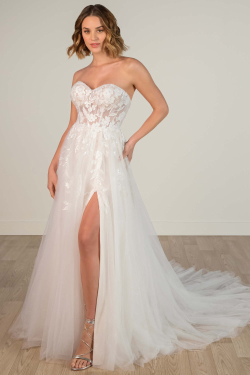 Chic strapless A-line wedding dress with sheer floral bodice and flowy skirt with slit. Chic strapless A-line wedding dress with sheer floral bodice and flowy skirt with slit.