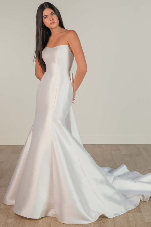 Modern and minimalist, this strapless gown features a sleek silhouette and dramatic flared hem Modern and minimalist, this strapless gown features a sleek silhouette and dramatic flared hem