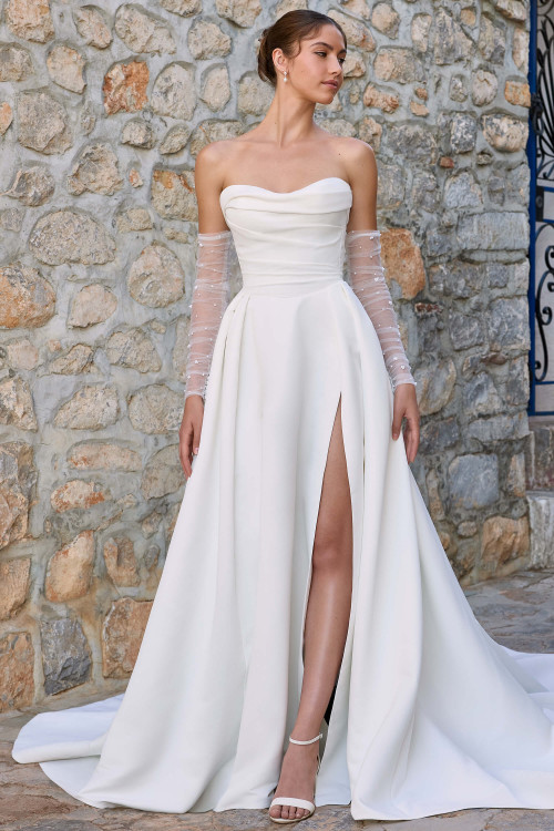 Full front view of Sophia Tolli Y3187, showing the dove satin A-line gown with sweetheart neckline, asymmetrical draped off-shoulder detail, and thigh-high slit. Full front view of Sophia Tolli Y3187, showing the dove satin A-line gown with sweetheart neckline, asymmetrical draped off-shoulder detail, and thigh-high slit.