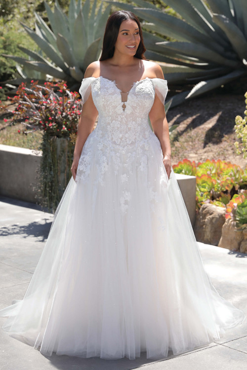 Front view of the Portrait by Enzoani Aurora plus-size ballgown with sweetheart neckline, lace bodice, and detachable tulle sleeves. Front view of the Portrait by Enzoani Aurora plus-size ballgown with sweetheart neckline, lace bodice, and detachable tulle sleeves.