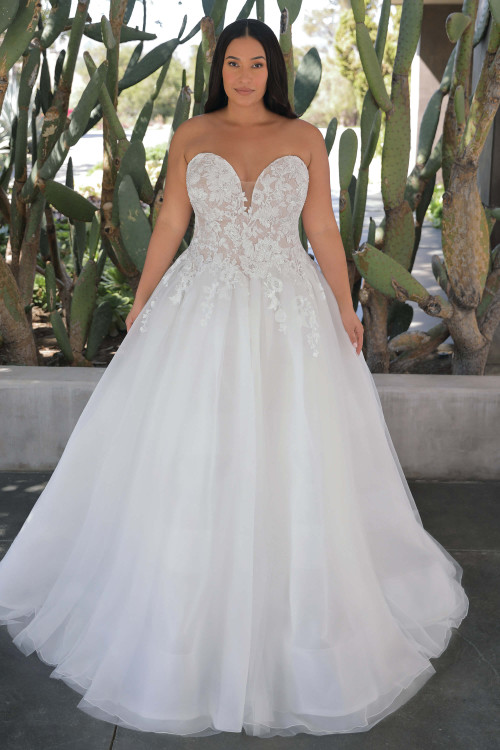Front view of the Portrait by Enzoani Genevieve plus-size ballgown with strapless sweetheart neckline and sparkling floral lace bodice. Front view of the Portrait by Enzoani Genevieve plus-size ballgown with strapless sweetheart neckline and sparkling floral lace bodice.