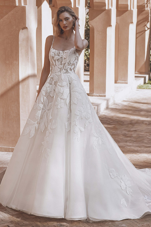 Bride in Enzoani Umi A-line gown with scoop neckline and 3D floral appliqués. Bride in Enzoani Umi A-line gown with scoop neckline and 3D floral appliqués.
