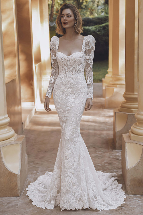 Bride in Enzoani Urvashi fitted gown with removable lace jacket, front view. Bride in Enzoani Urvashi fitted gown with removable lace jacket, front view.