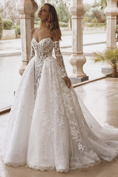 Bride wearing Enzoani Valen ballgown with floral lace and dramatic train, front view. Bride wearing Enzoani Valen ballgown with floral lace and dramatic train, front view.