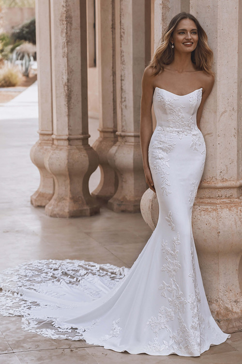 Front view of Enzoani Veda gown with scoop neckline and floral lace detailing. Front view of Enzoani Veda gown with scoop neckline and floral lace detailing.
