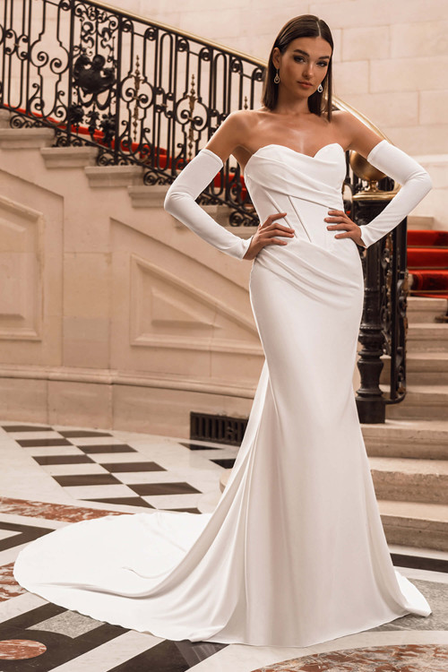 Front view of the ÉLYSÉE Fifi fitted gown with sweetheart neckline, draped bodice, and detachable long sleeves. Front view of the ÉLYSÉE Fifi fitted gown with sweetheart neckline, draped bodice, and detachable long sleeves.