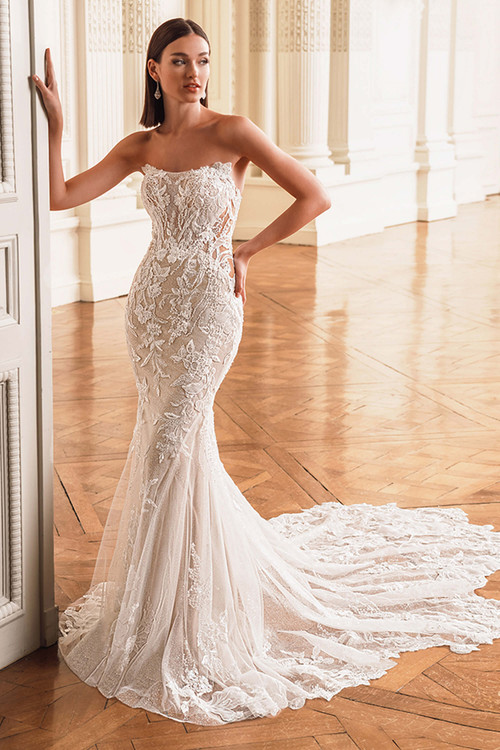 Front view of the ÉLYSÉE Franz fit-and-flare gown with curved square neckline, lace bodice, and illusion side cut-outs. Front view of the ÉLYSÉE Franz fit-and-flare gown with curved square neckline, lace bodice, and illusion side cut-outs.