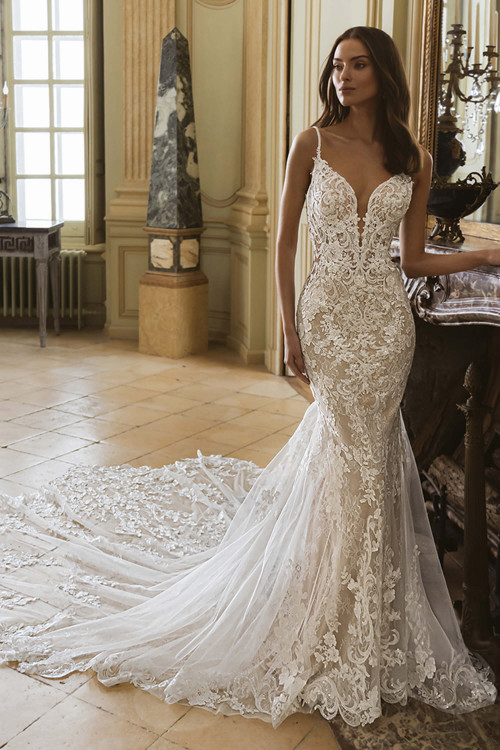 Front view of the ÉLYSÉE Geneva mermaid gown with plunging V-neckline, floral lace bodice, and flowing train. Front view of the ÉLYSÉE Geneva mermaid gown with plunging V-neckline, floral lace bodice, and flowing train.
