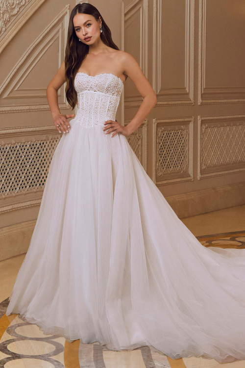Front view of Morilee Rhiannon gown with lace appliqués and flowing overskirt. Front view of Morilee Rhiannon gown with lace appliqués and flowing overskirt.