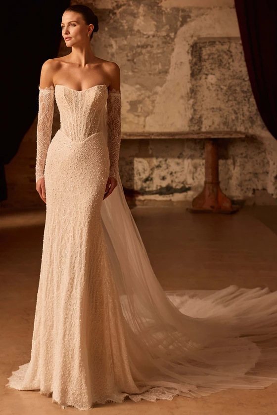 Front view of Pronovias Peia beaded Chantilly lace fit-and-flare wedding dress with detachable sleeves and cape