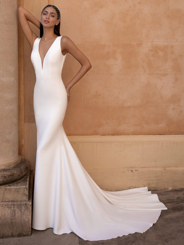 Sculpted to perfection—this sleek crepe gown stuns with a deep plunge neckline and minimalist train Sculpted to perfection—this sleek crepe gown stuns with a deep plunge neckline and minimalist train