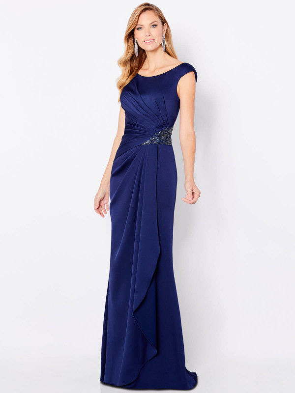 Elegant navy gown features gathered pleats and beaded applique at the side waist