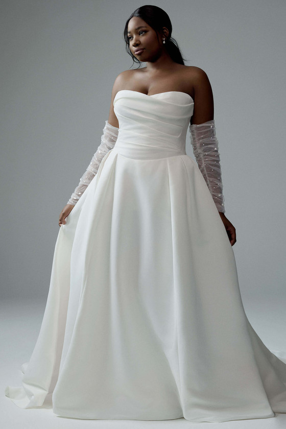 Front view of TY3187 in dove satin, A-line skirt, sweet-heart sweetheart neckline with off-shoulder draped detail and gauntlet sleeves.