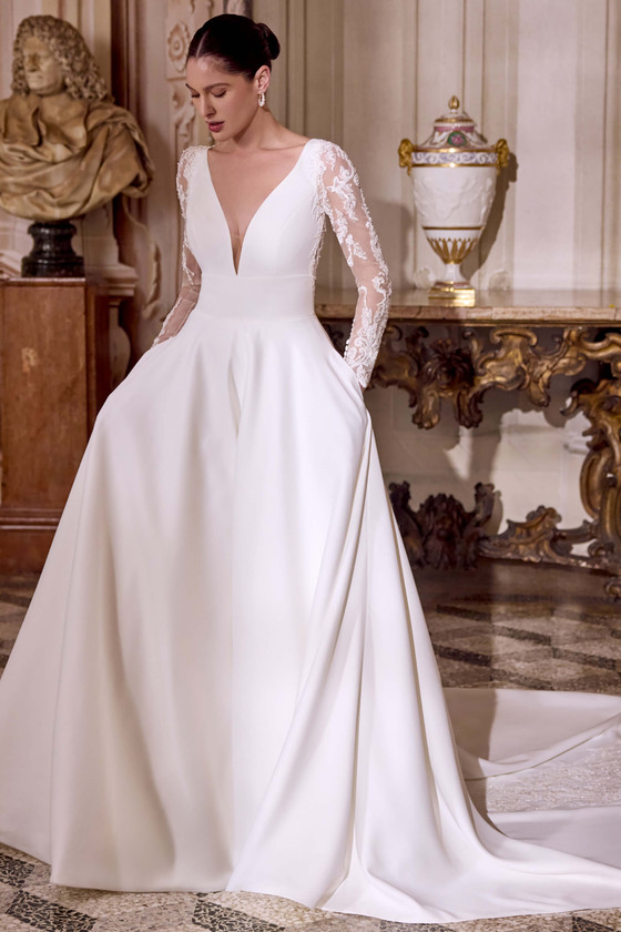 Justin Alexander Lisbeth A-line wedding dress in matte satin with plunging V-neckline and soft tulle long sleeves.
