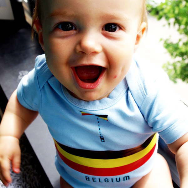 Smiling baby wearing a Belgium-themed cycling onesie