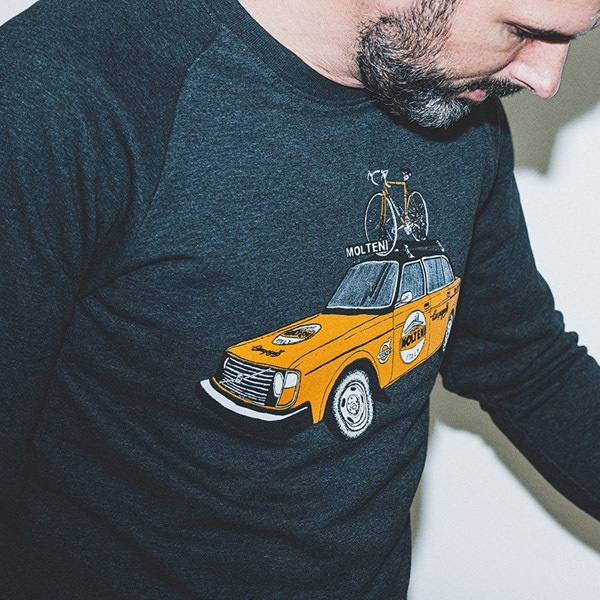 Man in dark tee with vintage car and bike design.