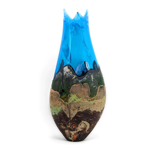 Vertically oblong handblown glass vase with deep interwoven earth tones along the bottom evoking the image of mountains contrasted against the bright, clear blue glass of the upper portion