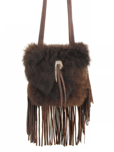 Buffalo fur handbag hanging against a white background with long tassels trailing from the bottom edge and an antler clasp in the center Buffalo fur handbag hanging against a white background with long tassels trailing from the bottom edge and an antler clasp in the center
