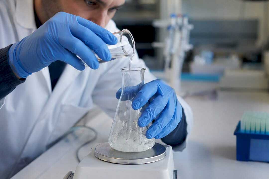 Técnico de laboratorio añadiendo agente solubilizante a muestra de proteína