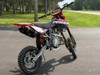 2024 Piranha Daytona 190-4V DE (Dual Exhaust), a high-performance competition pit bike designed for serious riders. The bike features a sleek and aggressive design with a dual exhaust system, emphasizing its power and performance. The Daytona Anima 190 4-valve engine and oversized oil cooler are highlighted, showcasing the bike’s robust power and efficient cooling. The ENGI adjustable suspension (800mm front forks and 330mm rear shock) is prominently displayed, underscoring the bike’s superior handling and shock absorption. The 14-inch front and 12-inch rear aluminum rims with Kenda Carlsbad tires add to the bike’s durability and traction. Overall, the image captures the essence of a high-performance, competition-ready pit bike built to dominate the track.
