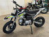 Thumpstar TSK 90cc mini bike, featuring its sleek mini stealth plastics, compact frame, and bold design. The bike is displayed in an action-ready stance, highlighting its inverted front suspension, oversized disc brakes, and Pipe Bomb muffler. The wrap-around frame and waterproof wiring are subtly visible, emphasizing the bike’s durability. The image also highlights the adjustable throttle limiter and emergency lanyard kill switch, key safety features for junior riders.