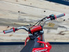 Denago MX3 Red Edition 140cc Pit Bike with bold red graphics, black powder-coated wheels, stainless steel exhaust, gold drive chain, and CNC anodized components for trail and off-road riding.