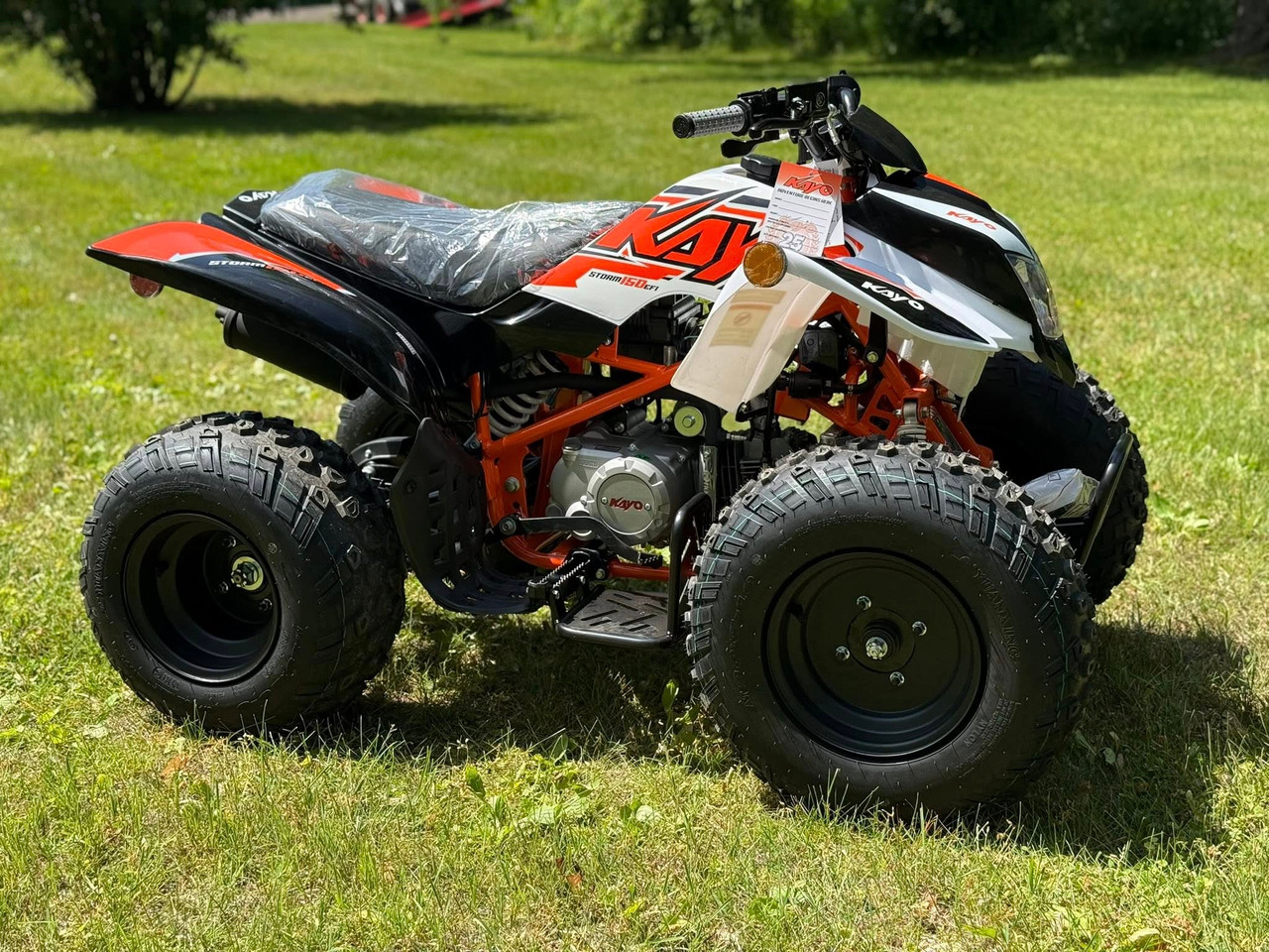 Kayo Storm 150 EFI ATV, a rugged and stylish all-terrain vehicle designed for off-road adventures. The ATV features a sleek black and red color scheme, with aggressive front tires, a double A-arm suspension system, and a sturdy frame. The image highlights the ATV's compact design, hydraulic disc brakes, and comfortable seat, making it an ideal choice for riders seeking performance and reliability on challenging terrains. Kayo Storm 150 EFI ATV, a rugged and stylish all-terrain vehicle designed for off-road adventures. The ATV features a sleek black and red color scheme, with aggressive front tires, a double A-arm suspension system, and a sturdy frame. The image highlights the ATV's compact design, hydraulic disc brakes, and comfortable seat, making it an ideal choice for riders seeking performance and reliability on challenging terrains.
