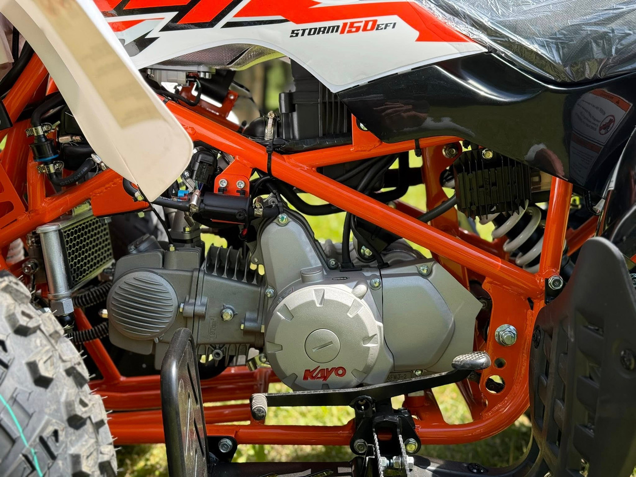 Kayo Storm 150 EFI ATV, a rugged and stylish all-terrain vehicle designed for off-road adventures. The ATV features a sleek black and red color scheme, with aggressive front tires, a double A-arm suspension system, and a sturdy frame. The image highlights the ATV's compact design, hydraulic disc brakes, and comfortable seat, making it an ideal choice for riders seeking performance and reliability on challenging terrains. Kayo Storm 150 EFI ATV, a rugged and stylish all-terrain vehicle designed for off-road adventures. The ATV features a sleek black and red color scheme, with aggressive front tires, a double A-arm suspension system, and a sturdy frame. The image highlights the ATV's compact design, hydraulic disc brakes, and comfortable seat, making it an ideal choice for riders seeking performance and reliability on challenging terrains.