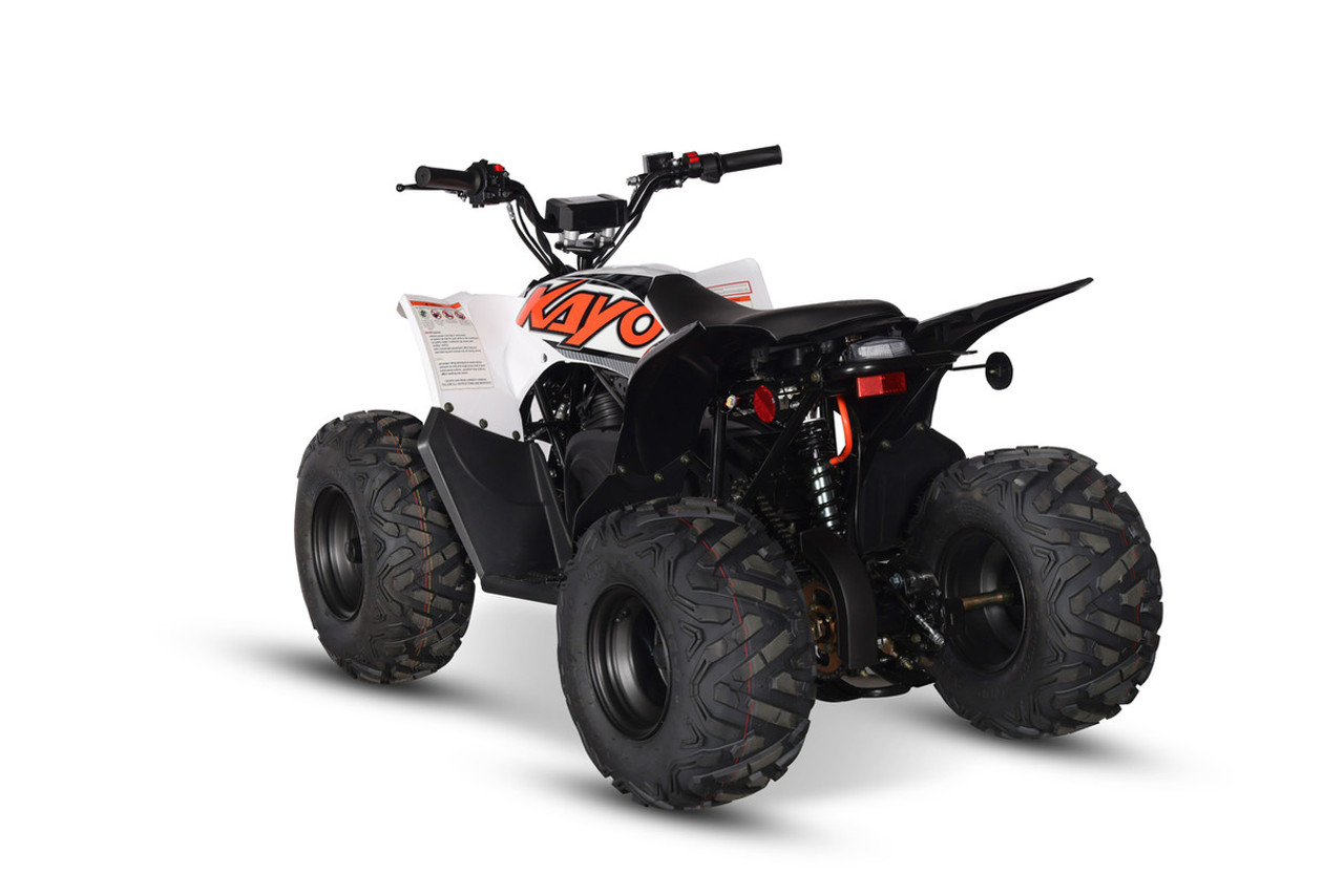 The image showcases the Kayo EA110 Electric Sport ATV, a sleek and modern off-road vehicle designed for young riders. The ATV features a robust frame, large off-road tires, and a comfortable seat. The front and rear hydraulic disc brakes, double A-arm front suspension, and adjustable rear shock are visible, highlighting the ATV's durability and performance. The electric motor and battery are seamlessly integrated into the design, emphasizing its eco-friendly and low-maintenance appeal. The image captures the ATV in action on a dirt trail, demonstrating its capability to handle various terrains with ease.