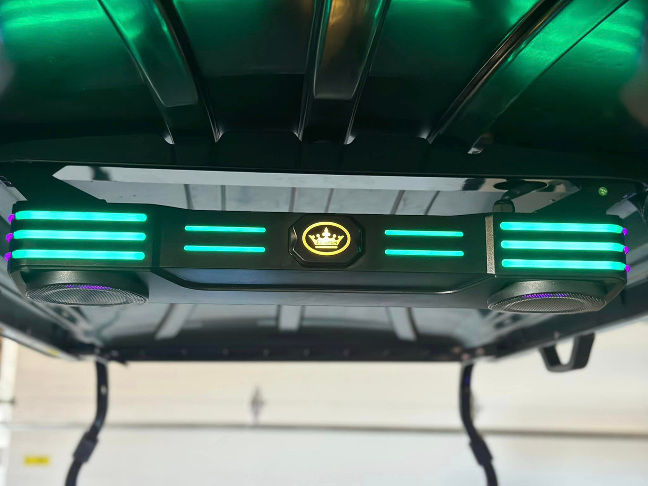 A close-up of the Premium Evolution Sound Bar shows its compact design with built-in speakers and woofers. The adjustable LED light modes sync with the music, creating a vibrant and immersive audio experience. The sound bar is wirelessly connected to the touchscreen, offering seamless control over your entertainment.