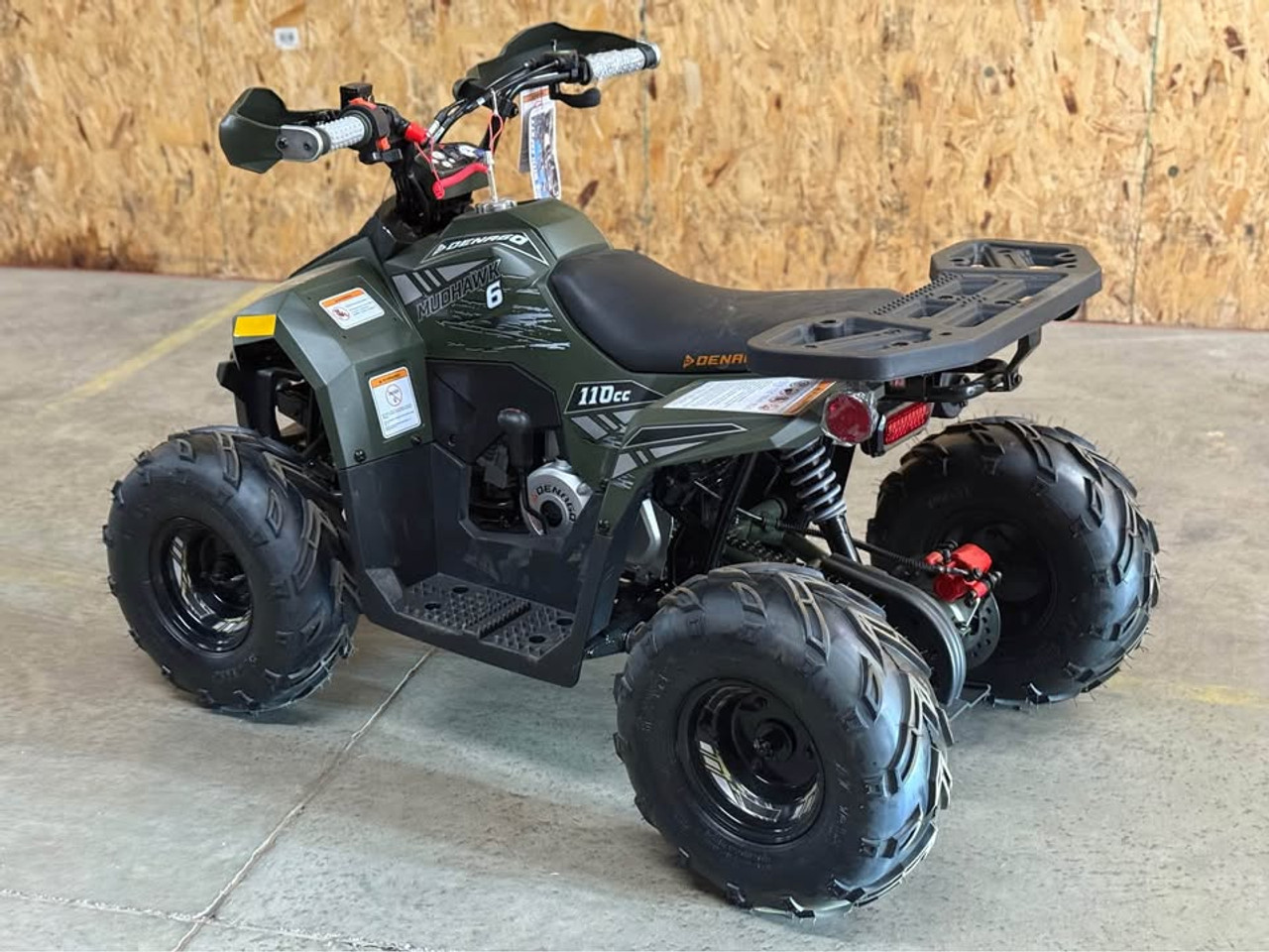 Matte green Denago Mudhawk 6 youth ATV with 107cc 4-stroke engine, automatic F-N-R transmission, LED headlights, rear cargo rack, independent front suspension, and remote wireless shut-off for kids aged 6 and up.