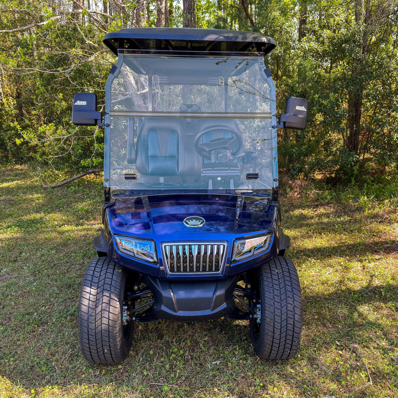 Clear DOT-certified folding windshield made from abrasion-resistant polycarbonate, mounted on an Evolution D5 Ranger/Maverick golf cart. The image shows the windshield in the upright position with clear visibility and robust bolt-on attachment, highlighting its road-legal design and durable, scratch-resistant finish.