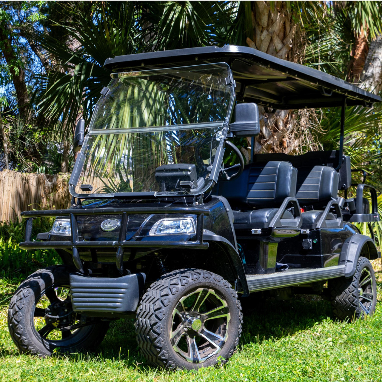 Tinted folding windshield mounted on an Evolution Forester golf cart, made from 1/4” thick acrylic with dual-pane design for glare reduction, weather protection, and adjustable airflow.